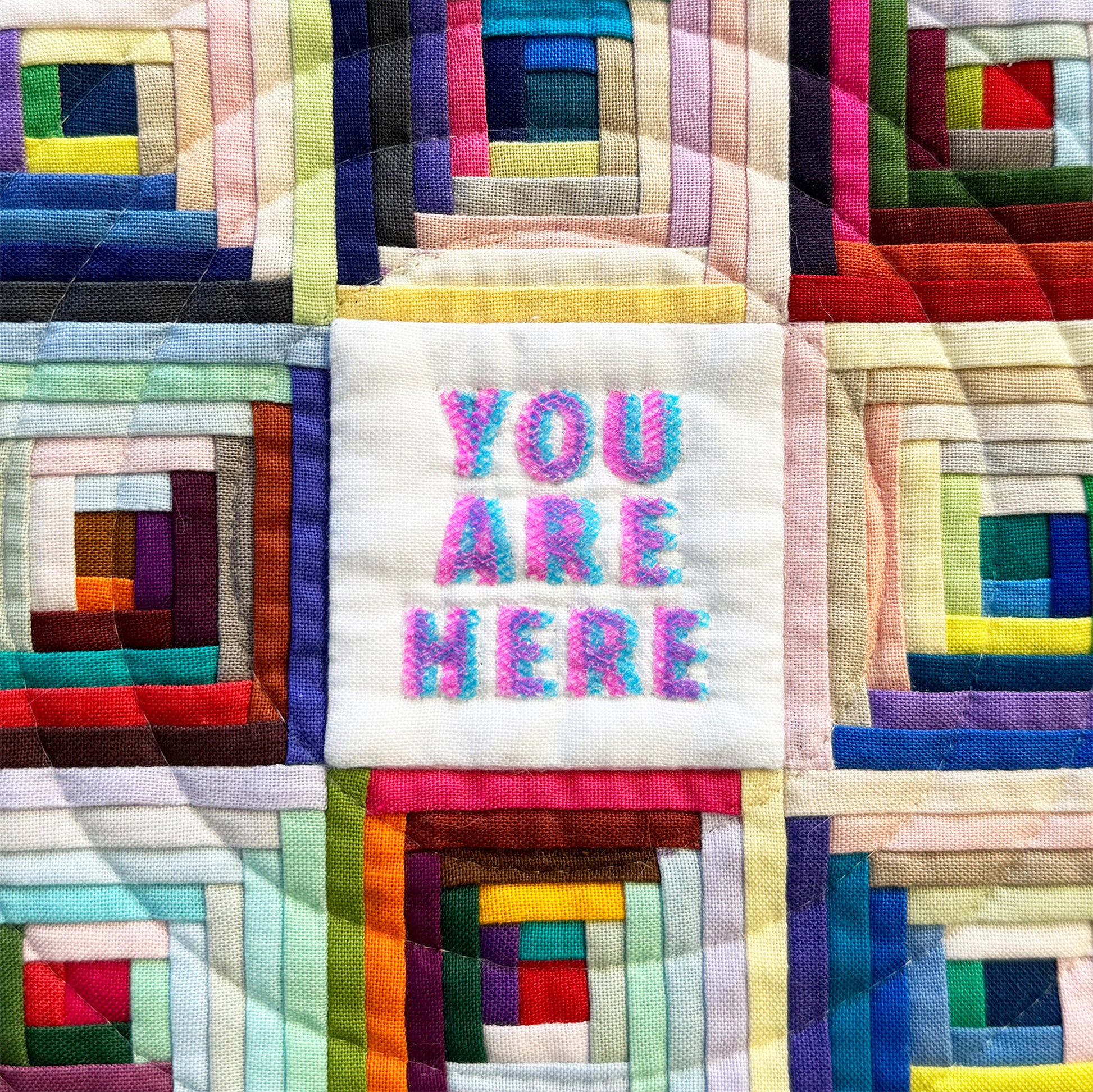 Colorful quilt with 'YOU ARE HERE' text in the center