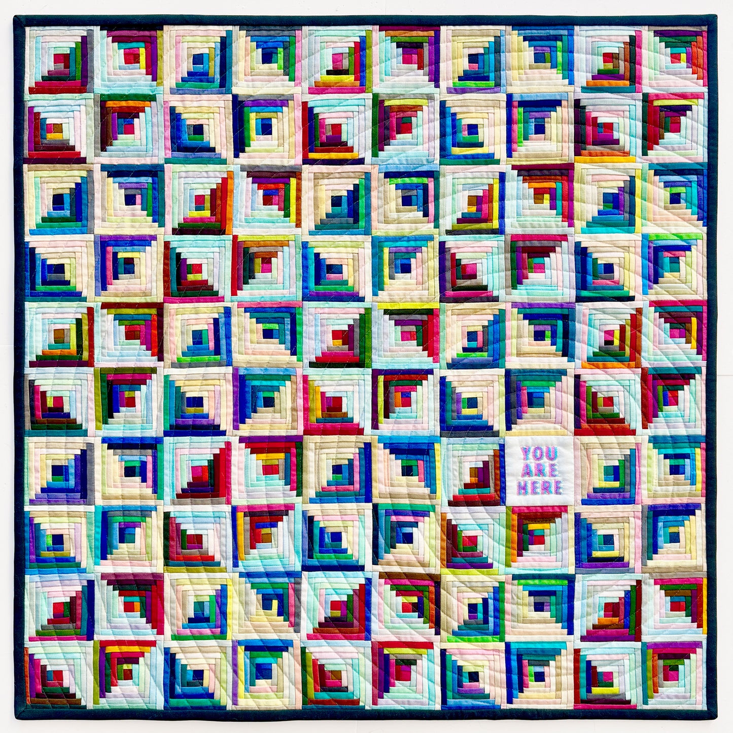 Colorful quilt with geometric pattern on a white background